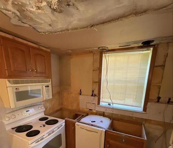 Water Damaged kitchen during the mitigation phase. Ceiling removed, cabinets remove, counter tops removed. 