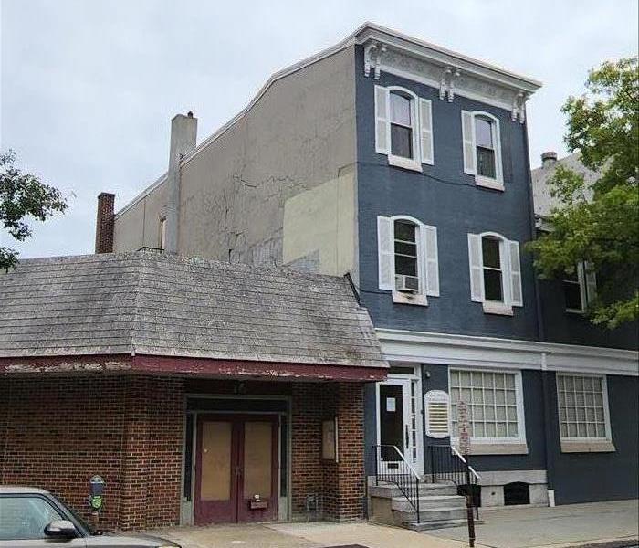 Commercial building in reading with vandalized stucco falling off of the wall.