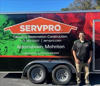 SERVPRO man stands in front of SERVPRO trailer