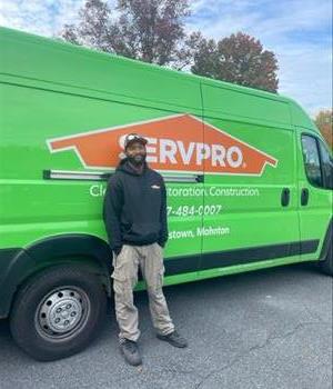 SERVPRO man stands in front of SERVPRO trailer