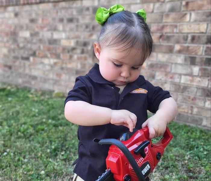 Juniper Joan Paul in SERVPRO Uniform holding toy chainsaw