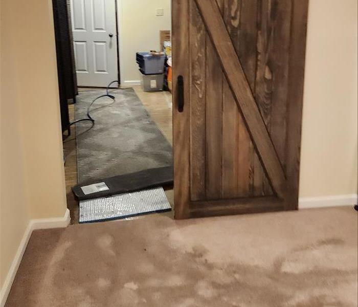 water seeping through carpet and cement floor in a finished basement.