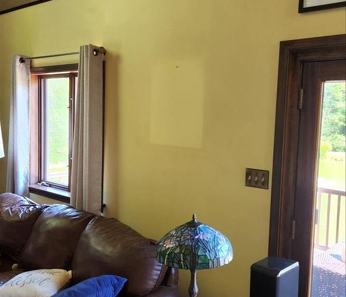 Yellow painted wall with significant nicotine staining. Outline from a hanging picture showing contamination level.